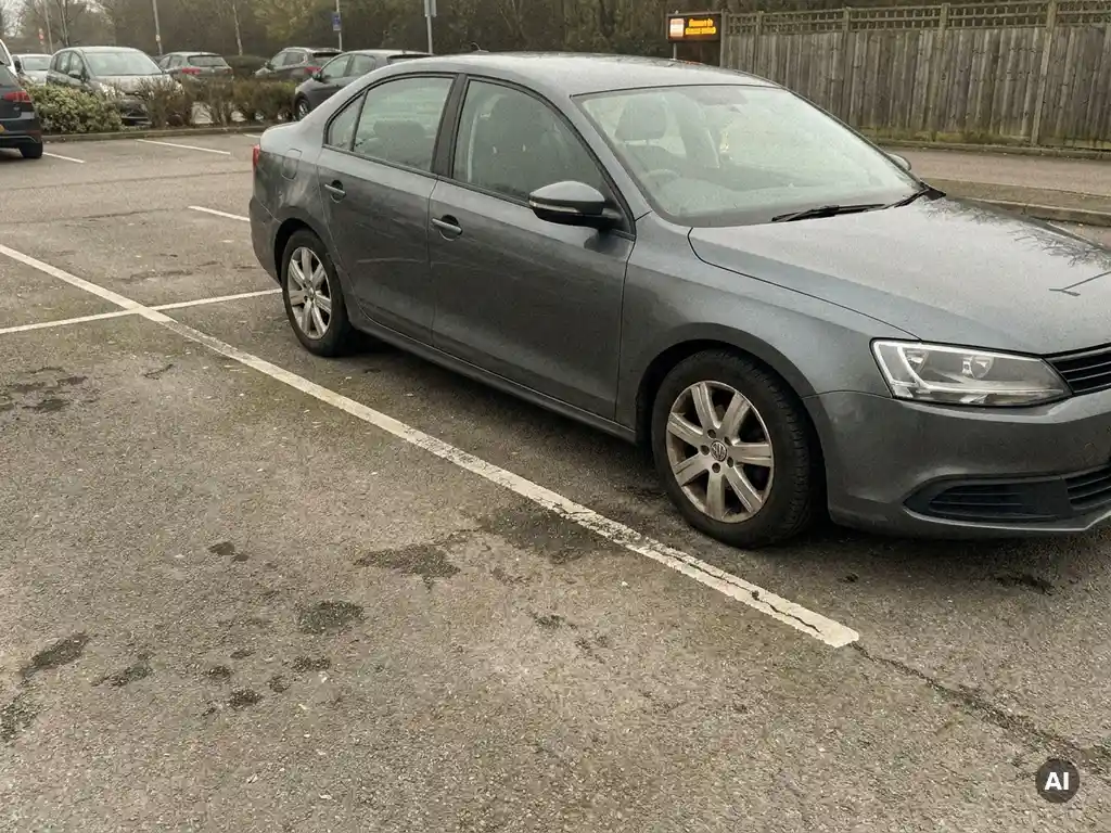 Auto parkt schräg über zwei markierte Stellplätze auf einem Privatparkplatz und blockiert eine freie Parkbucht.